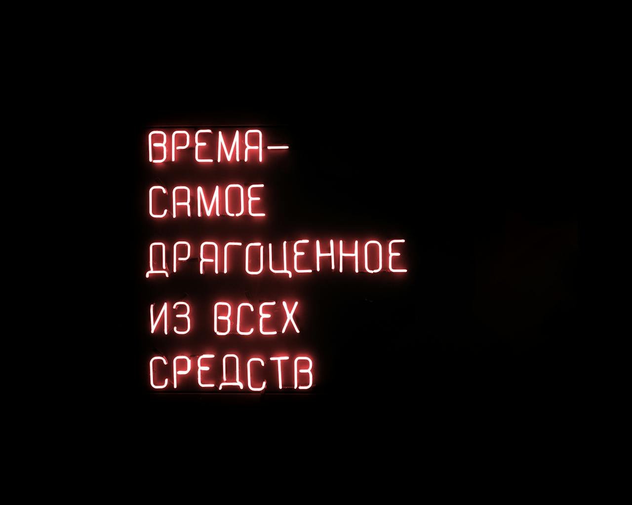 services-02 Glowing red neon sign with a motivational Russian text on a dark background.